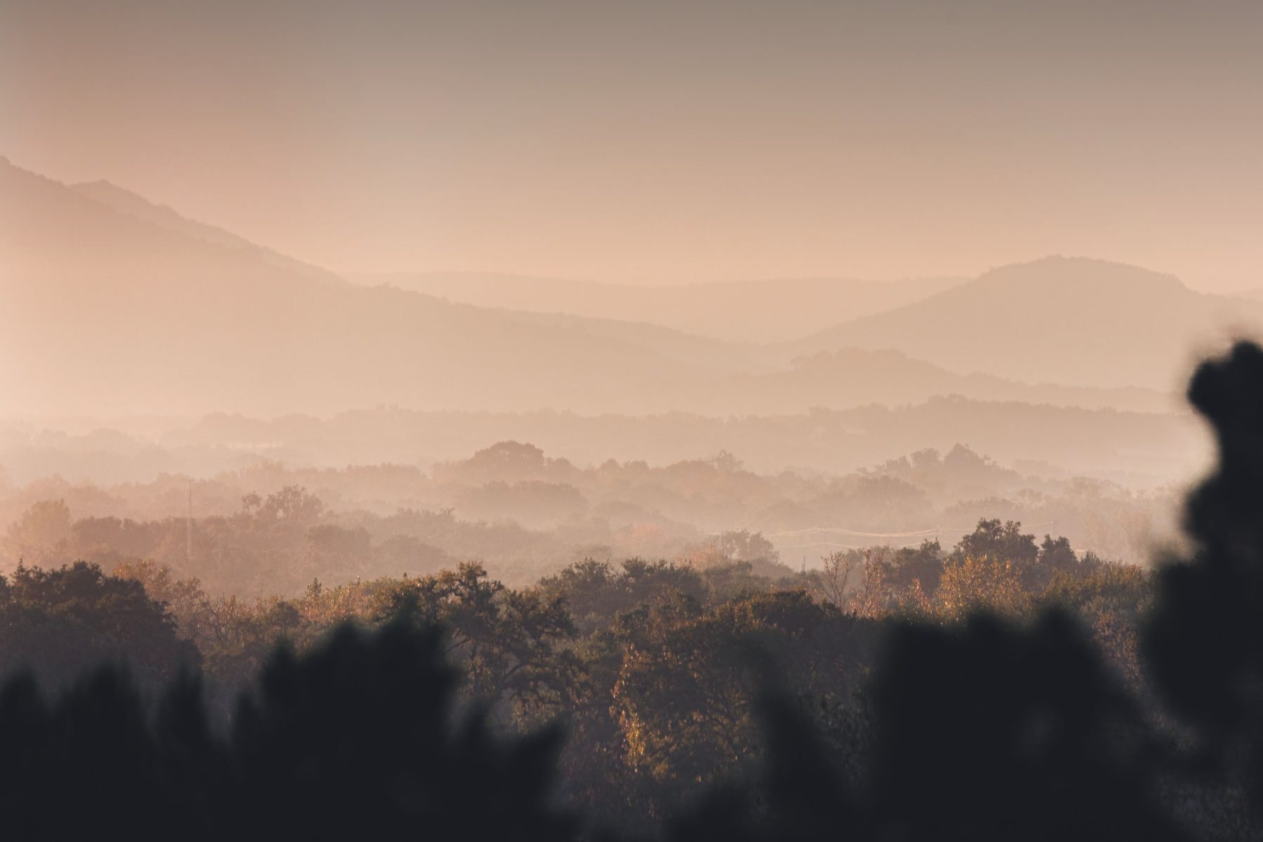 Layered ridgelines of the Texas Hill Country fading into morning haze at first light.